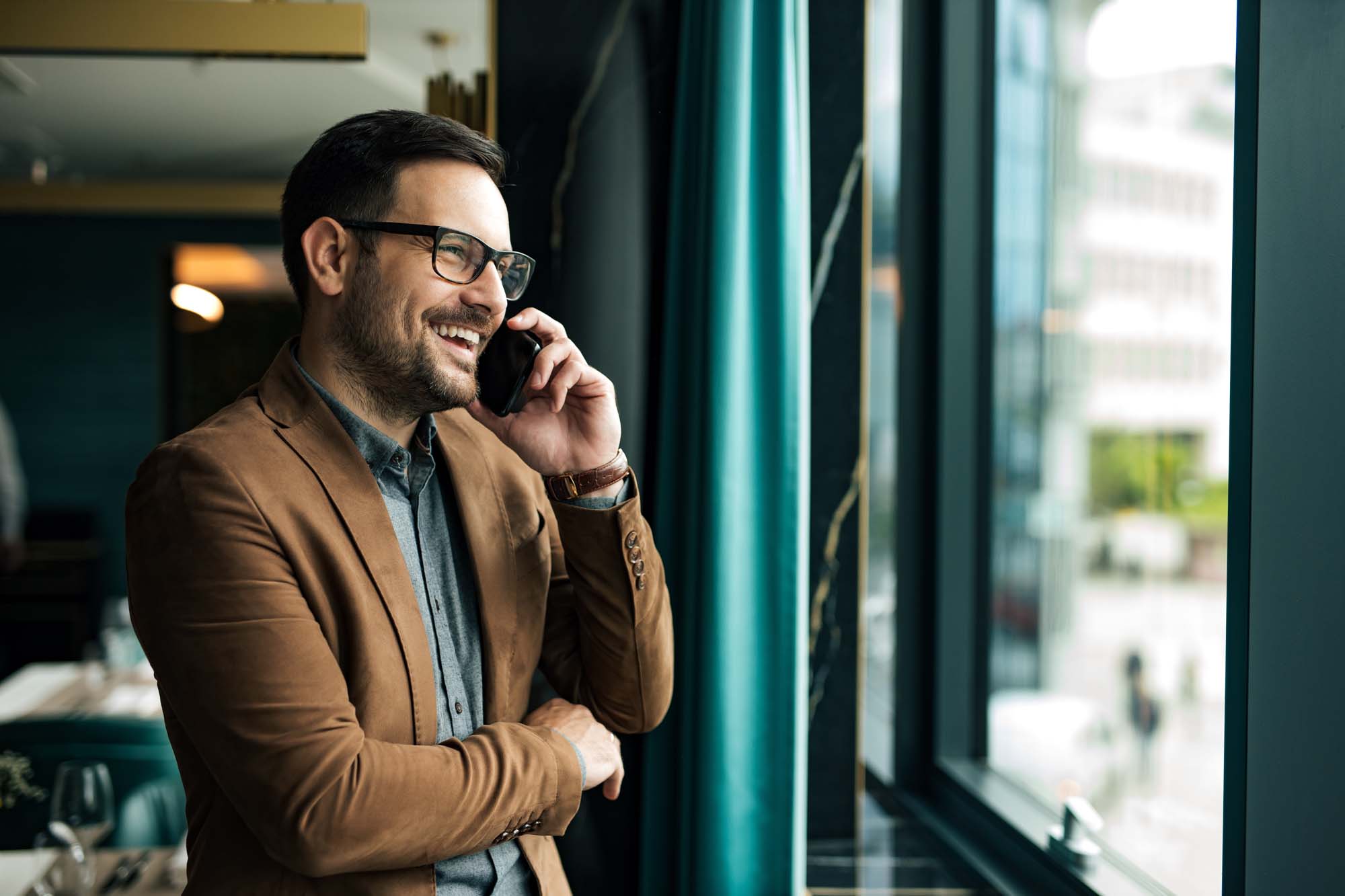 Portrait of a businessman smiling while having phone call. Stand