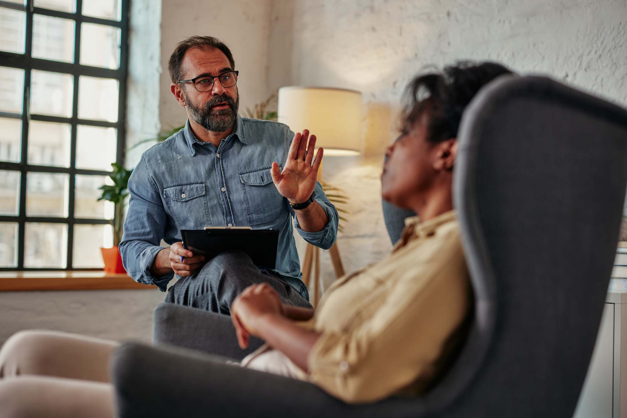 Male psychologist having session with african young adult patien