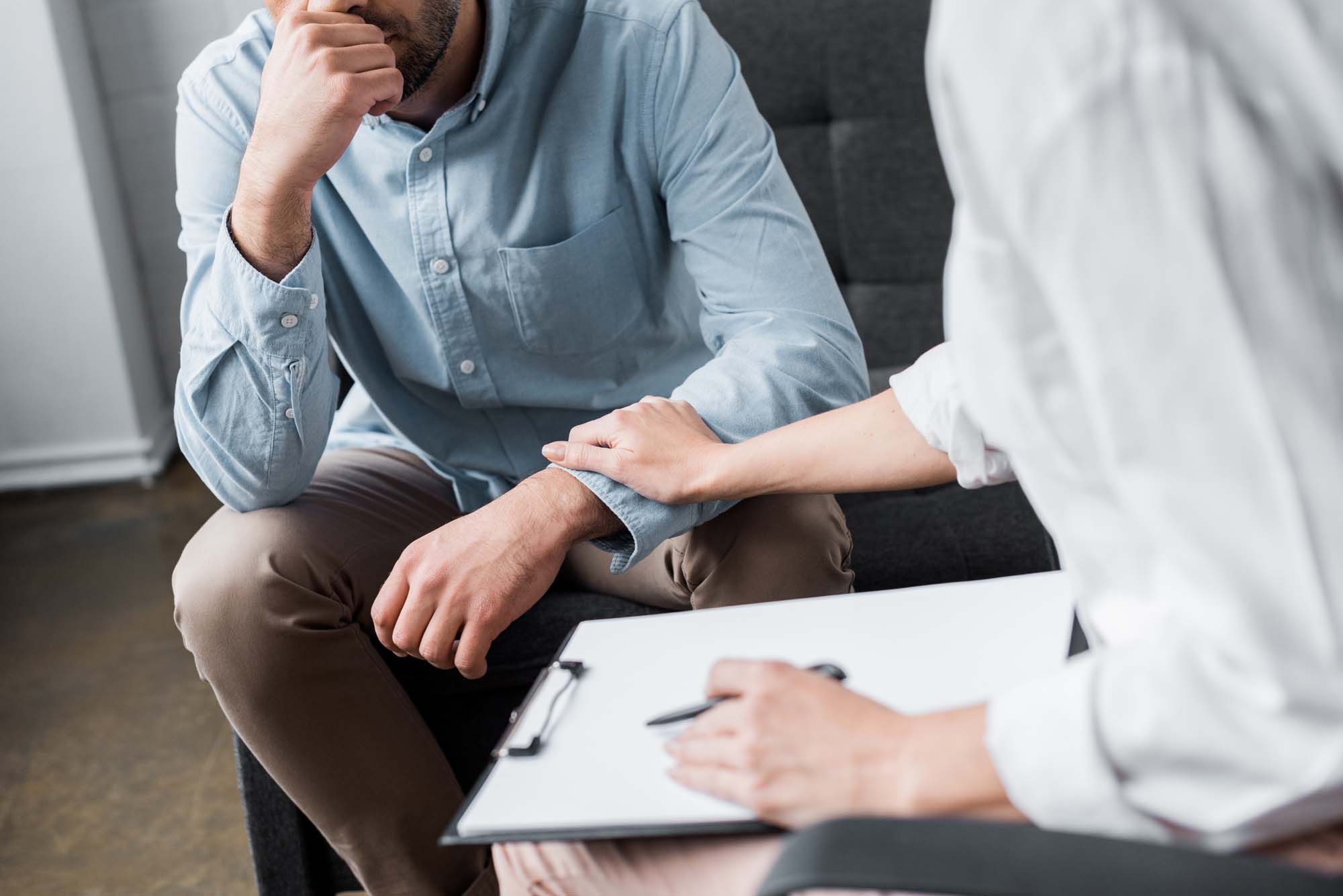 cropped shot of depressed adult man on psychologist therapy sess