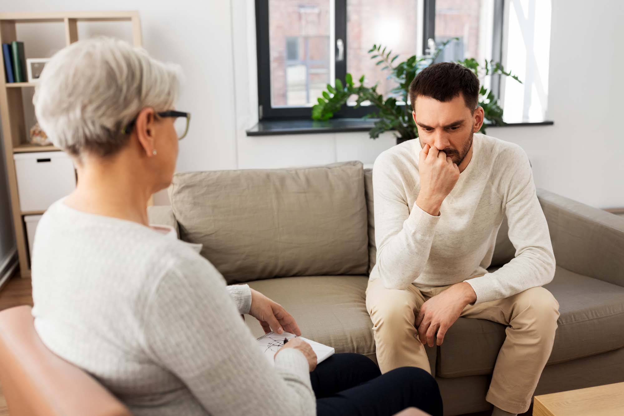 senior woman psychologist and sad man patient